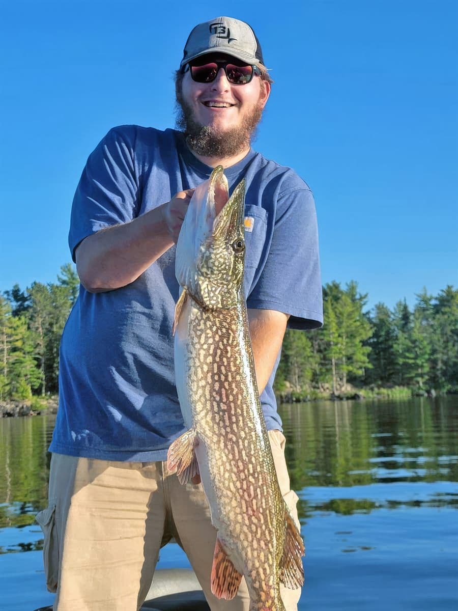 Jordan Riggs holding a northern pike on a lake in Northern Minnesota